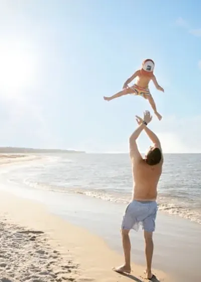 Pai brincando com filho na praia após recuperação